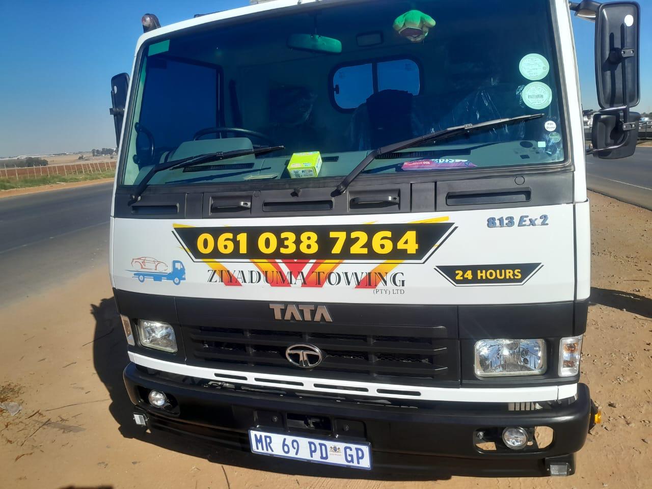 Front view of a branded Ziyaduma Towing Tata 813 Ex2 flatbed tow truck